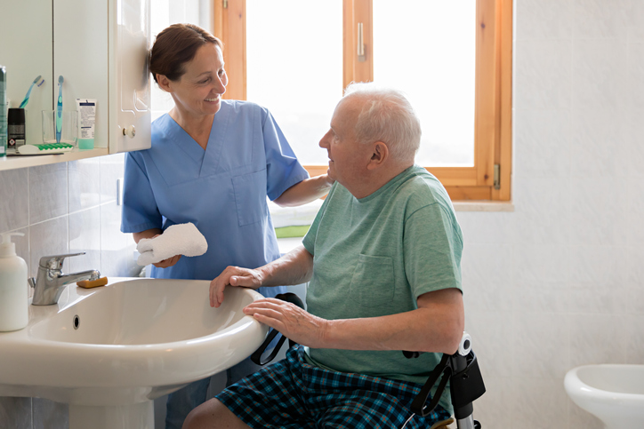 Caregiver assisting senior man in the bathroom