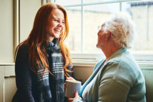 Young woman talks to senior woman about home health solutions.