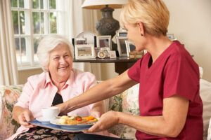 caregiver-serving-senior-woman-a-meal
