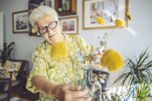 happy senior lady arranging flowers