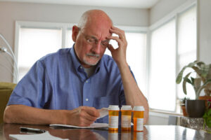 A senior man reviews his prescription medications to help prevent drug-related falls.