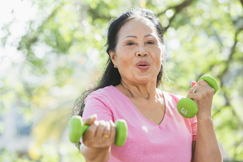 A woman uses hand weights to keep in shape. Exercising is one of the top strategies for stroke prevention in older adults.