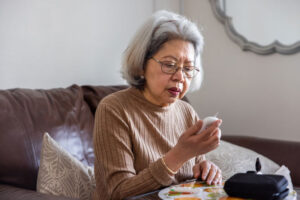 An older woman works at managing diabetes by testing her blood sugar.